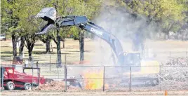  ?? GOOCH, THE OKLAHOMAN]
[PHOTO BY STEVE ?? Workers burn storm debris Thursday at Eldon Lyons Park in Bethany.