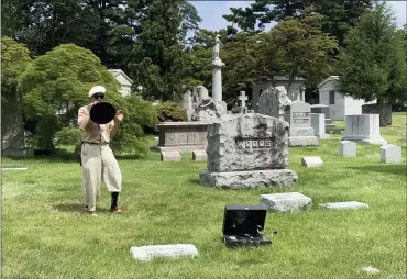  ?? (AP PHOTO/JULIA RUBIN) ?? Michael Cumella, aka DJ MAC, speaks through a vintage megaphone near the gravesite of Nat M. Wills, a vaudeville star of the early 20th century known as “The Happy Tramp” at Woodlawn Cemetery in the Bronx on June 27, 2021. Wills was among the jazz and vaudeville greats included on a tour led by Cumella.