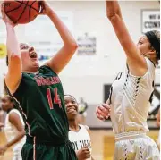  ?? Michael Minasi ?? The Woodlands’ Emma Warnsman (14) shoots as Conroe’s Riley Halloran (22) defends during the girls basketball game on Friday, Jan. 19, at Conroe High School.