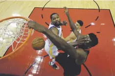  ??  ?? Rockets center Clint Capela, right, is hit in the face as he scores over Warriors forward Kevin Durant.