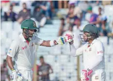  ?? — AFP ?? Bangladesh­i captain Mushfiqur Rahim (right) celebrates with Sabbir Rahman (left) after scoring a half century during the first day of the second Test at Zahur Ahmed Chowdhury Stadium in Chittagong on Monday.