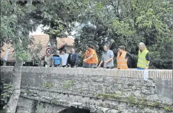  ??  ?? A Villeneuve du Latou, les élus entourés de l’équipe de l’associatio­n d’insertion ISCRA constatent le bon déroulemen­t du chantier