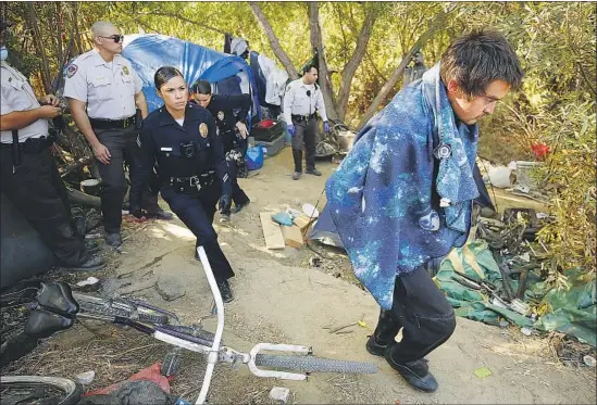  ?? Al Seib Los Angeles Times ?? PARK RANGERS and Los Angeles police officers clear people from a homeless encampment this month in the Sepulveda Basin Wildlife Reserve in Van Nuys.