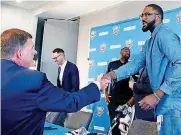  ?? [AP PHOTO] ?? Thunder chairman Clay Bennett shakes hands with freeagent acquisitio­n Patrick Patterson after Tuesday’s news conference. Bennett and the rest of the Thunder owners are on the hook for a projected $127.4 million in salary, but they have shown a...