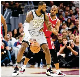  ?? JASON MILLER / GETTY IMAGES ?? LeBron James of the Cavaliers is defended by Chris Paul of the Rockets during the game Saturday in Cleveland. Houston won 120-88.