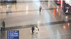  ?? REUTERS ?? People wearing face masks walk at Beijing Capital Internatio­nal Airport in Beijing, China yesterday.