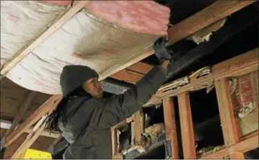  ?? KRISTI GARABRANDT — THE NEWS-HERALD ?? Loven’tay Ferguson, of Euclid, and a student in the Lake Shore Compact Constructi­on Management class, installs installati­on at the Meldon Drive house the students are renovating.