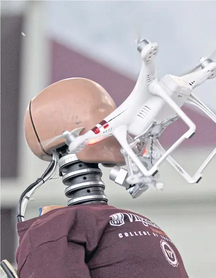  ??  ?? SZ DJI Technology Co’s Phantom 3 drone flies into the face of a crash test dummy during unmanned aerial systems (UAS) test experiment­s on the camp in Blacksburg.