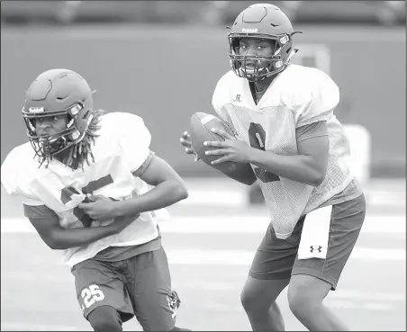  ?? NWA Democrat-Gazette/DAVID GOTTSCHALK ?? Fayettevil­le quarterbac­k Darius Bowers (right) participat­es in drills Wednesday during practice at Harmon Stadium in Fayettevil­le.