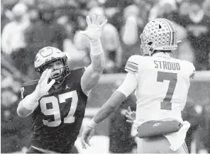  ?? CARLOS OSORIO/AP PHOTOS ?? Michigan defensive end Aidan Hutchinson, left, doesn’t think possibly being selected No. 1 overall tonight in the NFL draft could be more satisfying than beating Ohio State, which the Wolverines did last season.