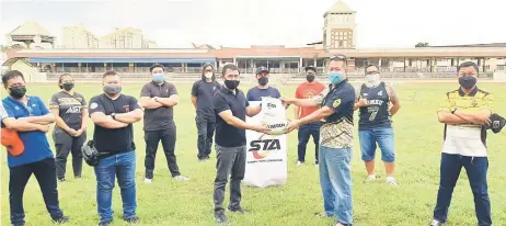  ?? — Photo by Ting Tieng Hee ?? Hafisz (left) presents a memento to Ahmad Yusop while STA and KRFC committee and members look on at Song Kheng Hai Rugby Ground last Saturday.