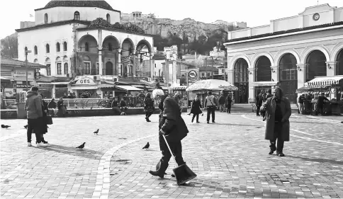  ??  ?? A street cleaner walks across Monastirak­i square in Athens, Greece, on Feb 9. — WP-Bloomberg photo