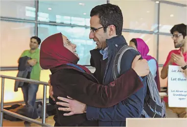  ?? STAFF PHOTOS BY FAITH NINIVAGGI ?? REUNITED: Mahdi Hashemian, right, hugs his mother-in-law, Akram Khajehali, and Moshen, above, embraces his mother, Kefayat, after the two women cleared customs at Logan airport yesterday.