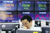  ?? AHN YOUNG-JOON/THE ASSOCIATED PRESS ?? A currency trader works at the KEB Hana Bank in Seoul on Thursday. Risk is a personal thing that means building the right portfolio to fit your needs, says Tom Bradley.