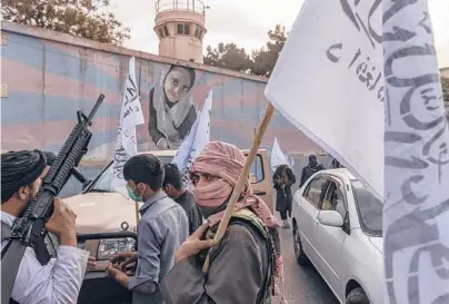  ?? VICTOR J. BLUE/THE NEW YORK TIMES ?? Taliban members gather outside the U.S. Embassy on Aug. 22 in Kabul, Afghanista­n.