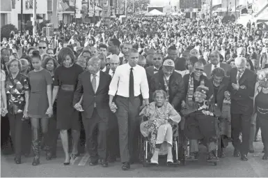  ?? JACQUELYN MARTIN/AP ?? On March 7, 2015, President Barack Obama, center, walks as he holds hands with Rep. John Lewis, D-Ga., and Amelia Boynton Robinson, both of whom were beaten during “Bloody Sunday.”