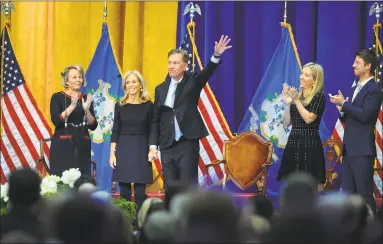  ??  ?? Hand in hand with wife, Annie, newly sworn-in Gov. Ned Lamont waves to a capacity crowd at the William A. O’Neill Armory in Hartford on Wednesday.