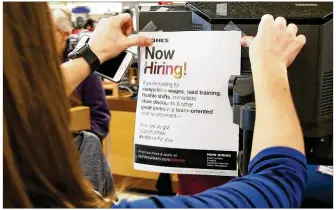  ?? TY GREENLEES / STAFF ?? Kohl’s store manager Brandy Duran posts a job flyer at the Centervill­e store. Area retailers are already trying to lock down their top seasonal job candidates.