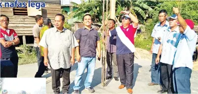 ??  ?? SAIRIN (berdiri, tengah) bersama penduduk dan kakitangan UPPM Liawan meninjau projek pembinaan rumah PBR di Kg Kadalakan.