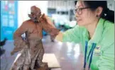  ?? YANG BO / CHINA NEWS SERVICE ?? A sculptor refines her work during a rural skills competitio­n in Nanjing, Jiangsu province, on Monday. The competitio­n had 13 categories, including carpentry, clay sculpture and fruit pit sculpture.