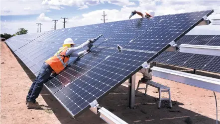  ?? NEW MEXICAN FILE PHOTO ?? Peter Scholtz, left, and Ryan Schneider of Positive Energy adjust solar panels in 2016 on the north side of Santa Fe High School. Lisa Randall, the sustainabi­lity program manager for Santa Fe Public Schools, said the tariff President Donald Trump...