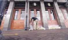  ?? DAVID J. PHILLIP/ASSOCIATED PRESS ?? Jake Summers puts concrete bags in front of a business in the French Quarter, on Friday, in New Orleans, ahead of Tropical Storm Barry.