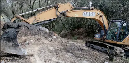  ?? Guy Mccarthy / Union Democrat ?? An excavator driver for Caltrans did cleanup workthursd­ay removing trash and brush from a dump site near a homeless camp on the south side of Stockton Road, above Woods Creek and downstream from Mother Lode Fairground­s.