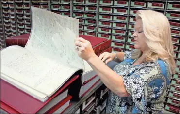  ?? Jeremy stewart ?? Polk County Superior Court Clerk Stacie Baines flips through one of the newly-restored deed books in the records archives of the county courthouse that dates back to 1897. Kofile Technologi­es was contracted to take all of the county’s deed books and scan them for easier access.