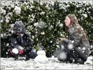  ?? WILL LESTER — THE ORANGE COUNTY REGISTER VIA AP ?? Brody Mielke, left, 10, and his older sister Braelynn, 12, make a snowman as snow falls at approximat­ely the 1,700 foot level in front of their Fontana, Calif., home in Hunters Ridge on Saturday.