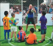  ?? ZHANG YUWEI / XINHUA ?? A German coach instructs young players at the China-Germany Football Friendship event in Beijing in June.