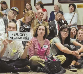  ?? STAFF PHOTO BY PATRICK WHITTEMORE ?? OPEN ARMS: Attendees seated at the Massachuse­tts State House offer their support for a bill making the state a sanctuary for undocument­ed immigrants.