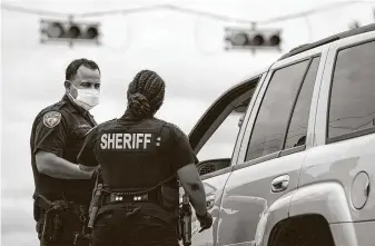  ?? Photos by Jon Shapley / Staff photograph­er ?? Harris County Sheriff’s deputies Aaron Herrera and Nakeitha Dussette speak to a motorist pulled over Wednesday at Bellaire and Metro boulevards in Houston.