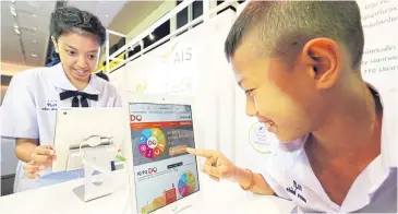  ??  ?? Children use tablets at the launch of AIS’s Aunjai Cyber campaign yesterday. The aim is to educate youth about online content.