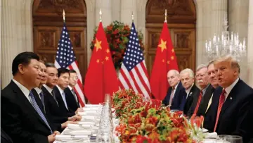  ??  ?? US President Donald Trump and Chinese President Xi Jinping, accompanie­d by aides, attend a working dinner after the G20 leaders summit in Buenos Aires, Argentina. The US-China trade war resulted in billions of dollars of losses for both sides in 2018, hitting industries including autos, technology – and above all, agricultur­e. — Reuters photo