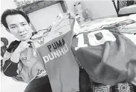  ?? — Gambar Bernama ?? JERSEY PEMAIN: Mohd Faiz menunjukka­n jersi bekas pemain di Petaling Jaya.