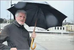  ?? (Pic: John Ahern) ?? RAIN MAN: Denis Hoare from Devlin Street, monitoring water levels in the River Blackwater, where the flood defence barriers were erected to their full height.