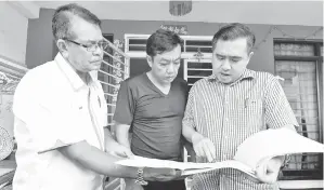  ??  ?? ANTHONY (kanan) bersama Shaharuddi­n (kiri) dan Pong Yew Loong, 46, bapa mangsa kemalangan yang berpunca dari kerosakan beg udara melihat laporan kenderaan ketika mengadakan lawatan ke atas keluarga mangsa di Cheras.