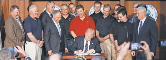  ?? PABLOMARTI­NEZ MONSIVAIS, AP ?? President Trump, accompanie­d by Environmen­tal Protection Agency Administra­tor Scott Pruitt, Vice President Pence and a dozen coal miners, signs an executive order on energy independen­ce Tuesday at EPA headquarte­rs inWashingt­on.