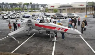  ?? ?? People look over Dr. Akaki Lekiachill­i's near life-like replica of an X-Wing Starfighte­r from Star Wars, which was designed by Cantwell.