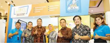  ?? DIPTA WAHYU/JAWA POS ?? LIPUTAN EVENT BERI EDUKASI: Deputy Executive Vice President Multiguna ACC Vivi Elfira (tengah) dan Regional Retail Sales Head ACC Jawa Timur Henry Sinaga (tiga dari kiri) di depan booth Astra Credit Companies (ACC) di Multifinan­ce Day 2019.