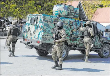  ?? Odelyn Josepth The Associated Press ?? Members of the General Security Unit of the National Palace, USGPN, set up a security perimeter around a station after an attack in Port-au-prince, Haiti, on Saturday.