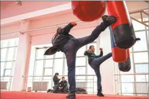  ?? ZHOU GANGFENG/ FOR CHINA DAILY ?? Top: Members of Alibaba’s Anti-Counterfei­ting Task Force discuss the geographic­al distributi­on of fake goods during a briefing session. Above: New team members work out at a training facility