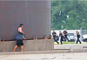  ?? FRED SQUILLANTE/COLUMBUS DISPATCH ?? At Anheuser-busch brewery, State Highway Patrol Trooper Brandon Todd portrays a terrorist who takes cover after shooting at arriving police officers.