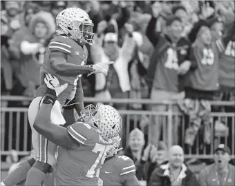  ?? JAY LAPRETE/AP PHOTO ?? Ohio State receiver Johnnie Dixon, top, celebrates his touchdown during the No. 10 Buckeyes’ 62-39 win over No. 4 Michigan on Saturday in Columbus, Ohio.