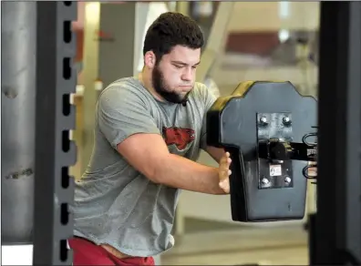  ?? NWA Democrat-Gazette file photo ?? Arkansas Razorbacks offensive lineman Shane Clenin, one of nine players who enrolled early for spring classes, works out in the weight room at the Fred W. Smith Center in Fayettevil­le. The Razorbacks went through an eight-week winter training program,...