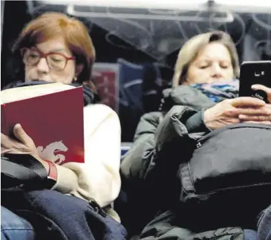  ?? DAVID CASTRO ?? Dos mujeres en el metro de Madrid, una leyendo un libro y otra mirando el móvil.