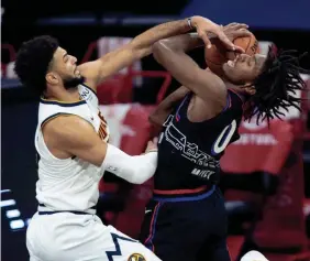  ?? BILL STREICHER/USA TODAY SPORTS ?? Philadelph­ia 76ers guard Tyrese Maxey (0) drives for a shot against Denver Nuggets guard Jamal Murray during the second quarter Saturday at Wells Fargo Center. The visiting Nuggets won 115-103.