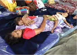  ?? ARUN CHANDRABOS­E ?? A woman rescued by the Navy from Kalady rests along with her grandchild­ren at the Naval relief camp in Kochi. —