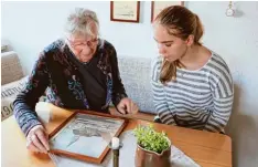  ?? Foto: Veronika Lintner ?? Ingrid Wolf zeigt heute gerne jungen Menschen, wie hier Carmen Schwab, das Bild ihres Kindheitsh­auses sowie andere Zeitdokume­nte.