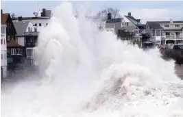  ?? MICHAEL DWYER /ASSOCIATED PRESS ?? A large wave crashes into a seawall in Winthrop, Mass., on Saturday, a day after a nor’easter pounded the Atlantic coast. Dozens were rescued from high waters.